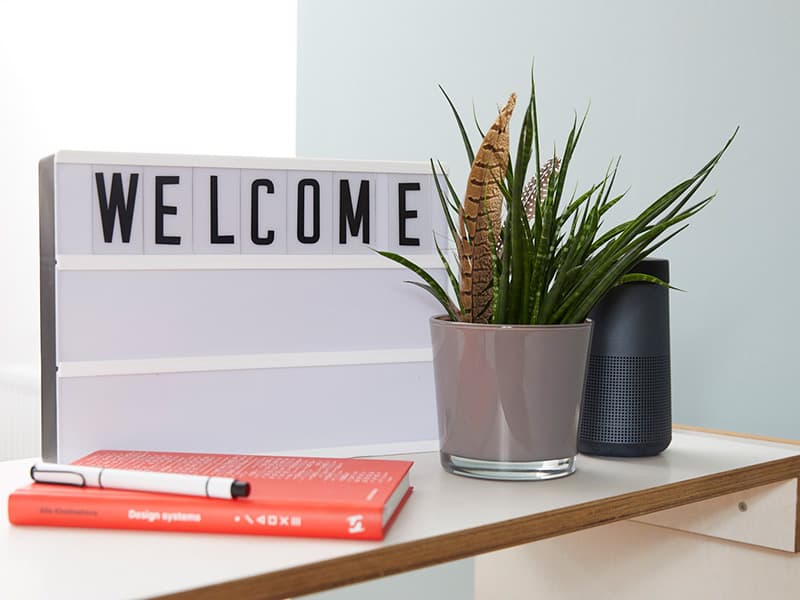Ein Schild mit der Aufschrift 'Welcome' und einige Topfpflanzen im Büro.